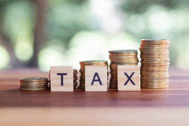 Kelime vergisi tahtadan fayanslar ve birikmiş paralarla yazılmış. Vergi artışı kavramı, iş, finans, ekonomi kavramı