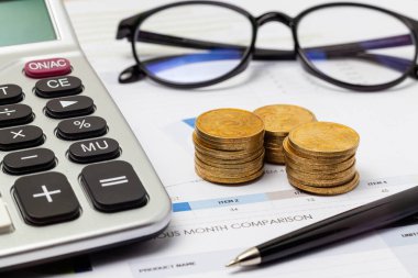 Hesap makinesi, madeni para ve bardaklar masada mali raporla birlikte. - Evet. İş ve mali konsept.