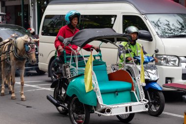 Malioboro, Yogyakarta 'da motosiklet çeken yaşlı bir adam. 29 Ocak 2025