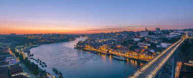 Porto ve vila nova de gaia 'yı birbirine bağlayan Dom Luis Köprüsü ve Douro Nehri' ni aydınlatan renkli günbatımı Portekiz 'de nefes kesici bir panoramik şehir yaratıyor.