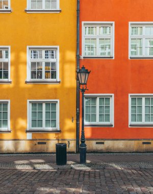Sıcak güneş ışığı gdansk, Polonya 'daki iki parlak bina arasındaki renkli bir kaldırım taşı caddesinde parlıyor.