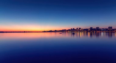 Estuario do Douro Yerel Doğa Koruma Alanındaki bir ağacın altında iki kişi oturuyorlar. Douro nehrinin üzerinde sakin günbatımının tadını çıkarıyorlar. Villa nova de gaia, Portekiz 'de.
