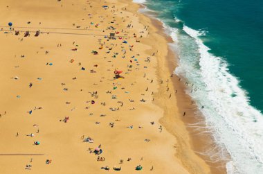 Naziler, Portekiz 'deki Praia de Nazare sahillerinin havadan görünüşü turistlerin güneşlendiğini ve yüzdüğünü gösteriyor. Yaz tatillerinin tadını çıkarıyorlar.