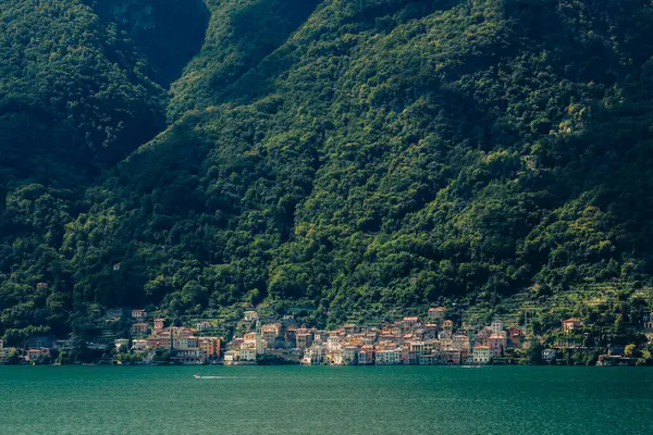 Gölün sakin turkuaz suları yemyeşil bir dağ sırasının dibine yerleşmiş büyüleyici bir İtalyan manzarası manzarası manzarası yaratan büyüleyici bir köyü yansıtıyor. Lezzeno 'dan alındı.