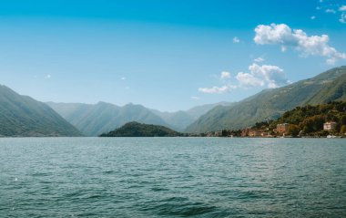 Como Gölü 'nün panoramik manzarası dağlar, mavi gökyüzü ve bulutlar Bellagio, Lombardiya, İtalya' da sakin sulara yansıyor, huzurlu ve huzurlu bir manzara yaratıyor.