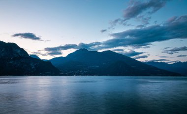 Como Gölü, alacakaranlık renklerini, arka plandaki dağları, Bellagio, Lombardy, İtalya 'dan uzun pozlama fotoğrafçılığını yansıtıyor.