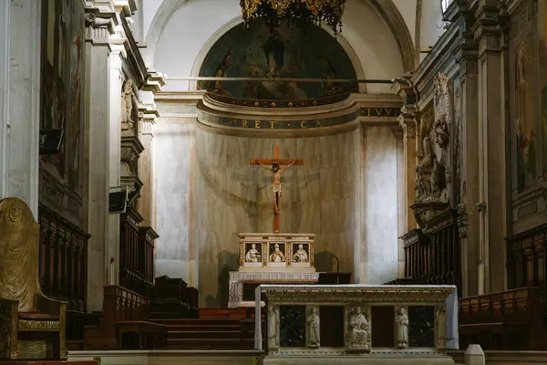 İtalya Treviso Katedrali 'nin içinde haçı aydınlatan güneş ışığı ve ana sunak, dini sanat, mimari ve dinsel inanç atmosferini gözler önüne seriyor.