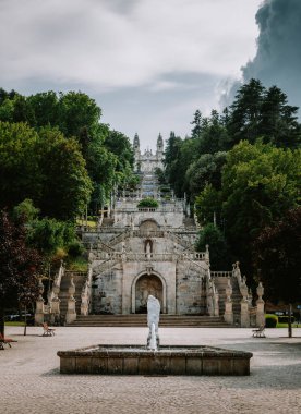 Portekiz, Lamego 'daki Nossa Senhora dos Remedios Sığınağı' nın geniş açılı görüntüsü barok mimarisini, çeşmeyi ve bulutlu bir gökyüzünün altında kiliseye yükselen büyük merdiveni gösteriyor.