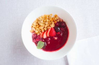 Beyaz masa örtüsü üzerinde taze bir akai kasesi sağlıklı ve şık bir kahvaltı..