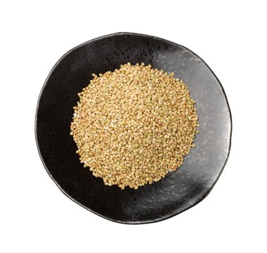 Raw Green Buckwheat Pile on Black Plate Isolated, Dry Buck Wheat Grains, Russian Kasha Heap, Uncooked Green Buckwheat Cut Out on White Background Top View