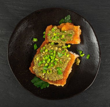 White Fish with Pesto, Grilled Cod Fillet with Green Sauce, Crispy Amritsari in Breadcrumbs, Pesto Fish on Black Background, Copy Space