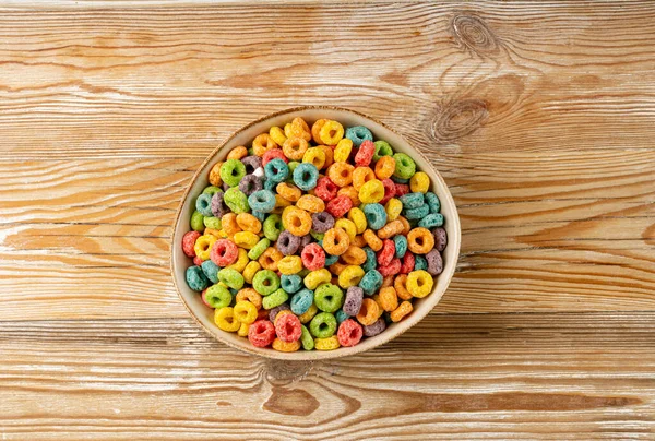 Colorful Breakfast Rings Pile, Fruit Loops, Fruity Cereal Rings, Colorful Corn Cereals on Wood Background