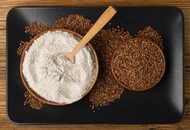 Buckwheat Flour Pile in Wood Bowl, Dry Buck Wheat Powder, Buckwheat Gluten Free Flour on Wooden Rustic Background Top View