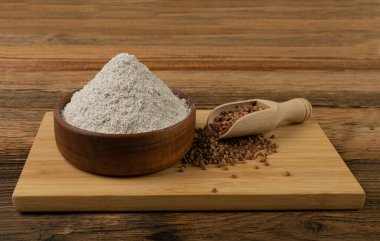Buckwheat Flour Pile in Wood Bowl, Dry Buck Wheat Powder, Buckwheat Gluten Free Flour on Wooden Rustic Background Side View
