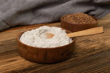 Buckwheat Flour Pile in Wood Bowl, Dry Buck Wheat Powder, Buckwheat Gluten Free Flour on Wooden Rustic Background Side View