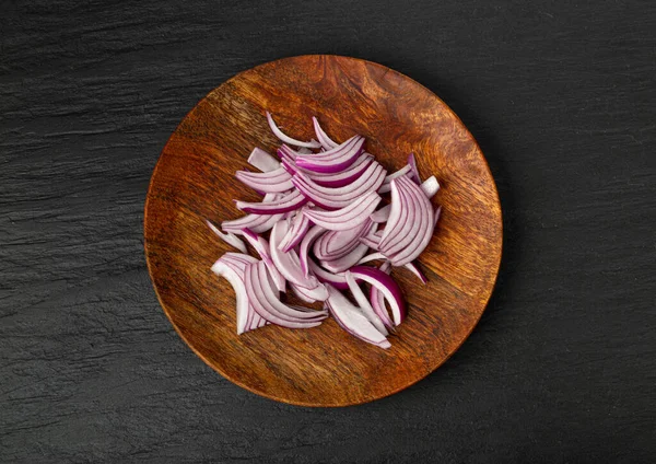 Red Onion Cuts on Wood Plate, Raw Purple Onion Slices, Chopped Purple Onion Pieces on Black Rustic Table Background Top View