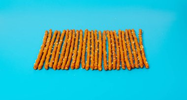 Ekmek Çubukları, Kraker Çubukları, Susam Grissini, Susam tohumlu Kraker Atıştırması, Mavi Arkaplanda Uzun Rusklar Üst Görünümü