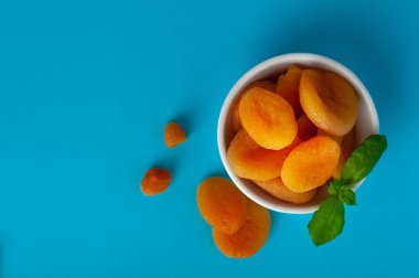 Yeşil Yapraklı Kuru Kayısı Yığını, Kasede Kurutulmuş Kayısı Yığını, Sağlıklı Portakal Meyveleri Grubu, Tatlı Organik Tatlılar, Sağlıklı Beslenme Yemeği, Mavi Arkaplanda Kuru Kayısı