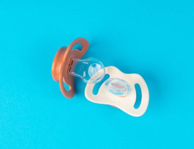 Emzik izole edilmiş, ortodontik bebek mankeni, lastik pastel çocuk yatıştırıcısı, mavi zeminde yeni sağlıklı silikon emzik.