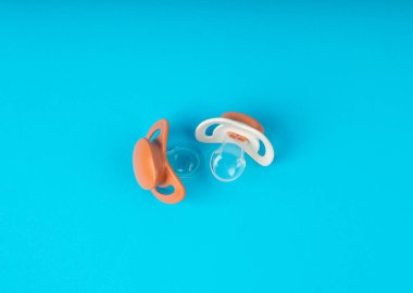 Emzik izole edilmiş, ortodontik bebek mankeni, lastik pastel çocuk yatıştırıcısı, mavi zeminde yeni sağlıklı silikon emzik.