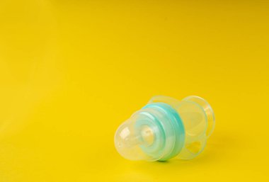 Bebek Kupası, Emzik ile Sarı Bebek Şişesi, Küçük Çocuk Ekipmanı, Plastik Çocuklar İçme Kabı, Sarı Arkaplanda Lid ile Bebek Besleme Şişesi