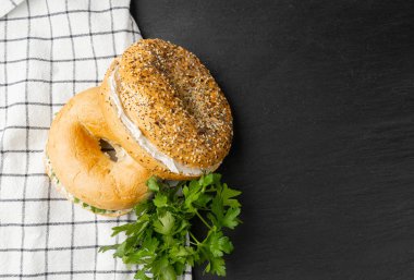 Yumuşak Peynirli ve Yeşillikli Yarım Simit, Yuvarlak Ekmek Çörekleri, Tahıllı Buğday Fırını ve Kahvaltı için Tohumlar, Siyah Arkaplanda Sade Çember Simit Ekmeği