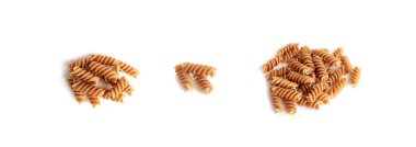 Çiğ kahverengi makarna, kepekli fusilli, tam tahıllı erişte, çiğ hamurlu makarna, sağlıklı İtalyan yemeği, organik yemek, beyaz arka planda kepekli sarımsaklı makarna.