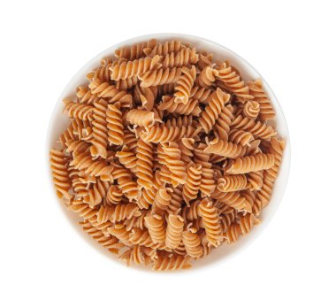 Çiğ kahverengi makarna, kabın içindeki kepekli fusilli istifi, kuru tam tahıllı erişte, çiğ hamurlu makarna, sağlıklı İtalya yemeği, organik yemek, beyaz arka planda kepekli sarımsaklı makarna.