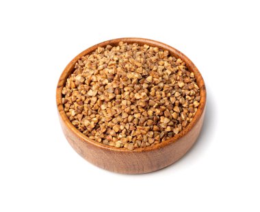 Çiğ karabuğday yığını ahşap kasede izole edilmiş, kuru buğday taneleri, Rus Kasha yığını, pişmemiş karabuğday kesimi beyaz arka planda.