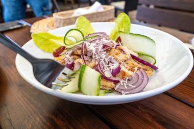 Sezar Salatası Kapanışı, Parmesan peynirli ızgara Tavuk Salatası, Yeşil Salata, Salatalık ve Salatalık, Beyaz Restoran Tabağında Sezar Salatası