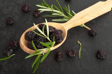 Kuru yaban mersini yığını, ahşap kaşıkta kurutulmuş yaban mersini, Cowberry Doğal Tatlısı, Sağlıklı Diyet, Organik Atıştırma, Kara Arkaplanda Kuru Yabanmersini Üst Görüş