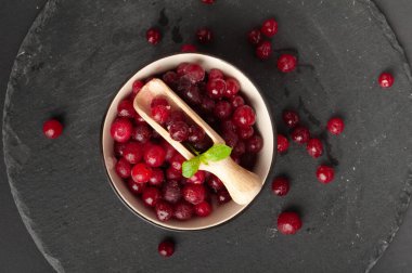 Donmuş Lingonberry, Dağılmış Buzlu Cowberry, Kara Bowl 'da Kar Yabanmersini, Kırmızı Viburum Böğürtlenleri, Kara Taş Arkaplanda Donmuş Lingonberry