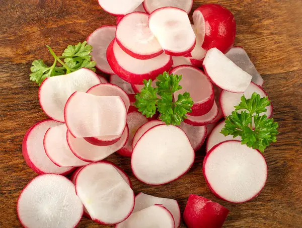 Sliced Radish Roots, Red Root Round Cuts, Red Radishes Slice Pile, Radis cross sections on Wood Plate, White Background Top View