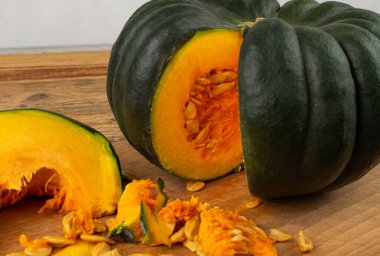 Ahşap masada kesilmiş yeşil balkabağı, tatlı kabak yuvarlak kabağı, tüm palamut kabağı kırsal arka planda yakın plan