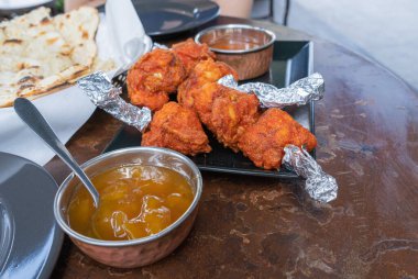 Haryali Tikka tavuğu, kızarmış tavuk parçaları, Hint caddesi restoranında acı kırmızı biberde tandır yemeği.
