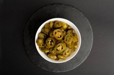 Turşulu Jalapeno Pile, Baharatlı Yeşil Jalapenos, Sıcak Meksika Biber Dilimleri Beyaz Kasede, Turşulu Yeşil Jalapeno Siyah Arka plan Top View