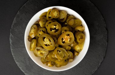 Turşulu Jalapeno Pile, Baharatlı Yeşil Jalapenos, Sıcak Meksika Biber Dilimleri Beyaz Kasede, Turşulu Yeşil Jalapeno Siyah Arka plan Top View