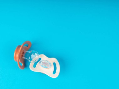 Emzik izole edilmiş, ortodontik bebek mankeni, lastik pastel çocuk yatıştırıcısı, mavi zeminde yeni sağlıklı silikon emzik.
