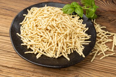 Bowl 'da çiğ trofie Makarnası, Kuru İtalyan Makarnası, Geleneksel Ceneviz Yemeği, Çiğ Erişte, Modern Ligurian Mutfağı, Tahta Kırsal Arkaplanda Trofie Makarnası