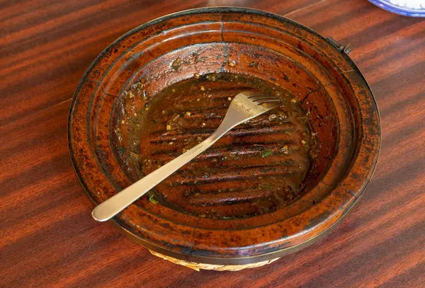 Dirty Moroccan Plate, Empty Bowl after Dinner, Finished Lunch, Oil and Smeared Sauce on Traditional Brown Plate