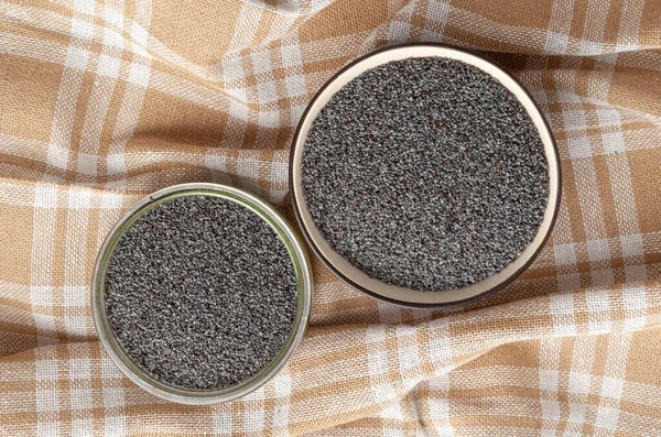 Poppy Seed in Bowls, Blue Poppyseed Pile in Glass Bowl, Small Culinary Grains, Tiny Seeds, Oilseed Sprinkles for Cooking, Poppy Seed on Checkered Tablecloth Background