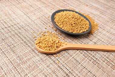 Fenugreek Tohumları Yığını, Kuru Trigonella, Baharatlı Methi Dana Tahılları Tahta Kaşıkla, Hint Mutfağı Baharatı İçindekiler, Kuru Sarı FenuYunan Tohumları