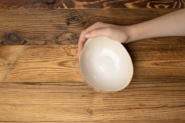 Bowl in Hands, Empty Bowl in Arms on Wooden Background, Vintage Kitchen Tableware Mockup, Dishware Banner, Empty Plate, Starving, Hungry Concept, Ceramic Bowl with Copy Space for Text