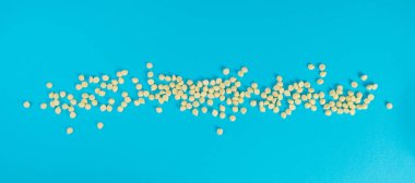 Beyaz çikolata parçaları, dağınık beyaz çikolata serpintileri, dekoratif kakao damlaları, Morsels, Kurabiye Dekorasyonu, Mavi Arkaplan Üst Görüş 'te Küçük Şekerleme Çipleri Parçaları