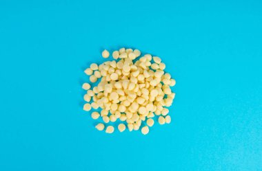 Beyaz çikolata parçaları, dağınık beyaz çikolata serpintileri, dekoratif kakao damlaları, Morsels, Kurabiye Dekorasyonu, Mavi Arkaplan Üst Görüş 'te Küçük Şekerleme Çipleri Parçaları