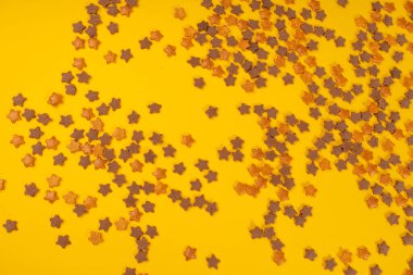 Cookie Stars Sprinkle, Sugar Star Pile, Candy Flakes, Sweet Brown Sprinkles Dekorasyonu, Candy Stars on Yellow Background Top View, Copy Space