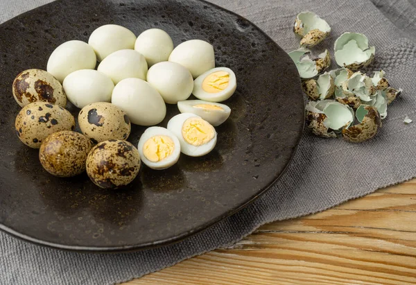 Peeling Diet Egg from Shell, Peeled Quail Eggs on Black Plate, Healthy Breakfast, Natural Organic Nutrition, Salad Ingredient Spotted Quail Egg on Rustic Background