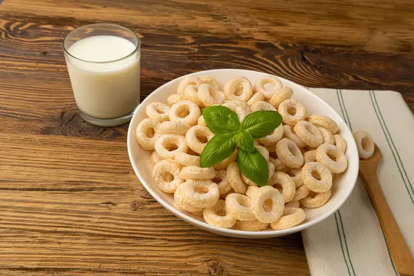 Cereal Rings on Wooden Table, Breakfast Rice Loops, Corn Cereals Snack on Rustic Background