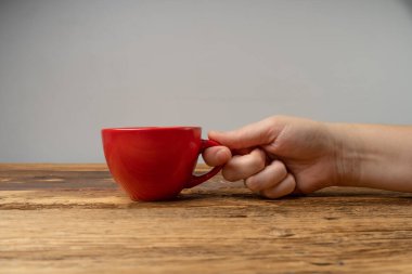 Hand Holds kupası, Ellerinde Boş Kırmızı Kupa, Kahve fincanı, Çay fincanı, Sıcak İçecek Mockup, Tahta Masa Arkaplan Arkaplanda Metin Tarafından Görünümlü Fotokopi Alanı