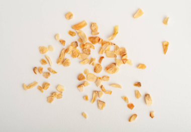 Kuru sarımsak dilimleri yalıtılmış, yağda kızartılmış karanfil istifi yakın plan, ızgara sarımsak gevreği, karanfilli cips grubu beyaz arka plan üst görünümü